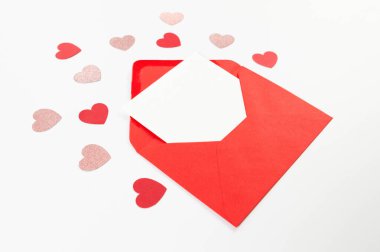 Kırmızı zarfın üst görüntüsü, beyaz arka planda beyaz kart. Sevgililer günü, pembe parıldayan kalpler, kırmızı kalpler, aşk. Düz yatay, kopyala boşluk.