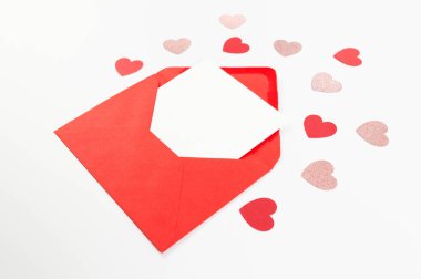 Kırmızı zarfın üst görüntüsü, beyaz arka planda beyaz kart. Sevgililer günü, pembe parıldayan kalpler, kırmızı kalpler, aşk. Düz yatay, kopyala boşluk.