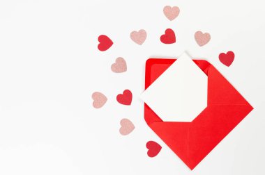 Kırmızı zarfın üst görüntüsü, beyaz arka planda beyaz kart. Sevgililer günü, pembe parıldayan kalpler, kırmızı kalpler, aşk. Düz yatay, kopyala boşluk.