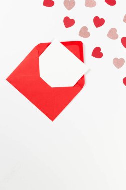 Kırmızı zarfın üst görüntüsü, beyaz arka planda beyaz kart. Sevgililer günü, pembe parıldayan kalpler, kırmızı kalpler, aşk. Düz yatay, kopyala boşluk.