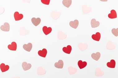 Beyaz arka planda renkli kalplerin üst görüntüsü. Pembe parıldayan kalpler, kırmızı kalpler, pembe kalpler. Sevgililer günü, duvar kağıtlarına bayılırım. Düz yat, boşluğu kopyala.