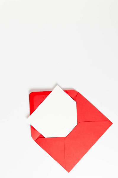 Top view of red envelope, white card on white background. Post flat lay. Copy space.