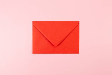 Pembe arka plandaki kırmızı zarfın üst görüntüsü. Yat yere. Boşluğu kopyala.