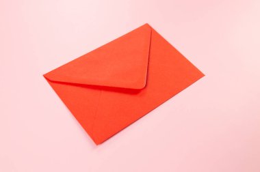 Pembe arka plandaki kırmızı zarfın üst görüntüsü. Yat yere. Boşluğu kopyala.