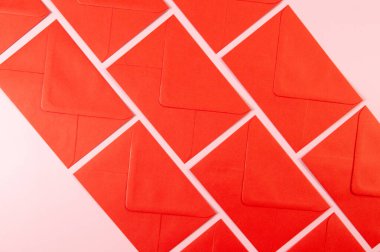 Pembe arka plandaki kırmızı zarfların üst görüntüsü. Yat yere. Boşluğu kopyala.