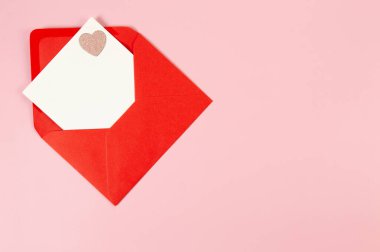 Kırmızı zarfın üst görüntüsü, pembe arka planda beyaz kart. Sevgililer günü, pembe pırıltılı kalp, aşkım. Düz yatay, kopyala boşluk.