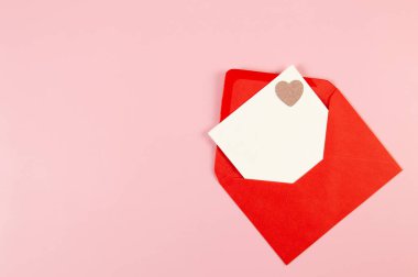 Kırmızı zarfın üst görüntüsü, pembe arka planda beyaz kart. Sevgililer günü, pembe pırıltılı kalp, aşkım. Düz yatay, kopyala boşluk.