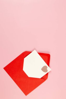 Kırmızı zarfın üst görüntüsü, pembe arka planda beyaz kart. Sevgililer günü, pembe pırıltılı kalp, aşkım. Düz yatay, kopyala boşluk.