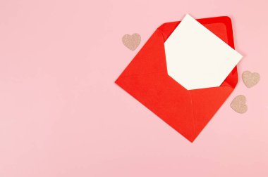 Kırmızı zarfın üst görüntüsü, pembe arka planda beyaz kart. Sevgililer günü, pembe parıltılı kalpler, aşkım. Düz yatay, kopyala boşluk.