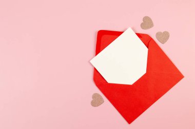 Kırmızı zarfın üst görüntüsü, pembe arka planda beyaz kart. Sevgililer günü, pembe parıltılı kalpler, aşkım. Düz yatay, kopyala boşluk.