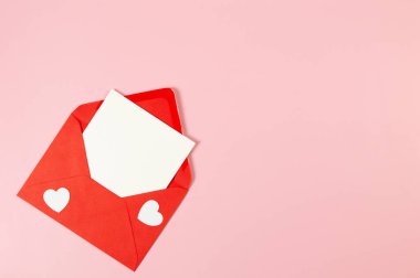 Kırmızı zarfın üst görüntüsü, pembe arka planda beyaz kart. Sevgililer günü, beyaz kalpler, aşk. Düz yatay, kopyala boşluk.