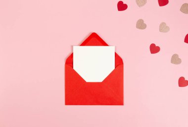 Kırmızı zarfın üst görüntüsü, pembe arka planda beyaz kart. Sevgililer günü, pembe parıldayan kalpler, kırmızı kalpler, aşk. Düz yatay, kopyala boşluk.