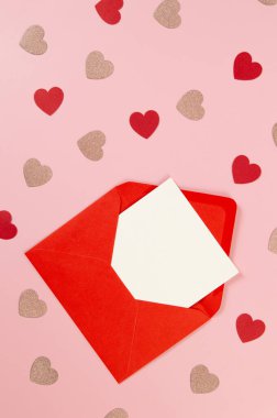 Kırmızı zarfın üst görüntüsü, pembe arka planda beyaz kart. Sevgililer günü, pembe parıldayan kalpler, kırmızı kalpler, aşk. Düz yatay, kopyala boşluk.