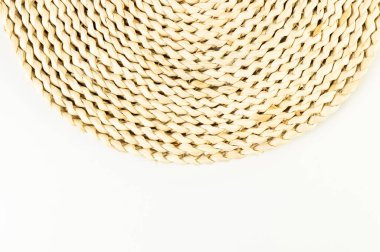 Beyaz arkaplandaki kahverengi hasır masa paspasının üst görüntüsü. Saman yuvarlak tepsi, düz konum, kopyalama alanı. 