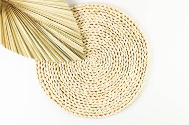 Kahverengi hasır masa paspası, beyaz arka planda kurutulmuş palmiye yaprağı. Saman yuvarlak tepsi, düz konum, kopyalama alanı. 