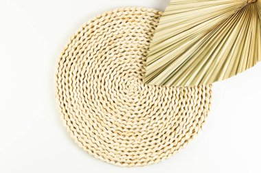 Kahverengi hasır masa paspası, beyaz arka planda kurutulmuş palmiye yaprağı. Saman yuvarlak tepsi, düz konum, kopyalama alanı. 