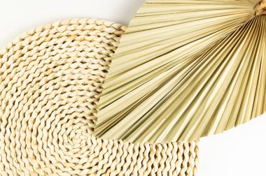 Kahverengi hasır masa paspası, beyaz arka planda kurutulmuş palmiye yaprağı. Saman yuvarlak tepsi, düz konum, kopyalama alanı. 