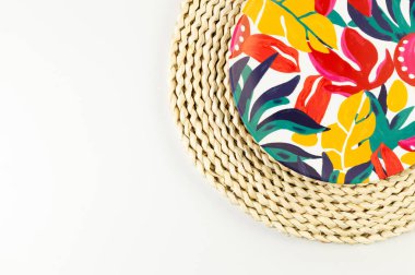 Kahverengi hasır masa paspasının üst görüntüsü, beyaz arka planda renkli plaka. Saman tepsisi, egzotik bitki tabağı, yaz pikniği. Düz yat, boşluğu kopyala. 