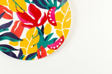 Beyaz arkaplandaki renkli plakanın üst görünümü. Egzotik bitki plakası, yaz pikniği. Düz yat, boşluğu kopyala.