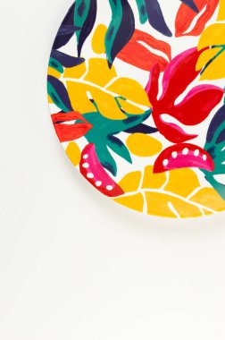 Beyaz arkaplandaki renkli plakanın üst görünümü. Egzotik bitki plakası, yaz pikniği. Düz yat, boşluğu kopyala.