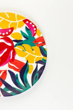 Beyaz arkaplandaki renkli plakanın üst görünümü. Egzotik bitki plakası, yaz pikniği. Düz yat, boşluğu kopyala.