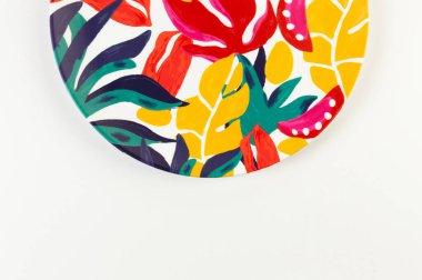 Beyaz arkaplandaki renkli plakanın üst görünümü. Egzotik bitki plakası, yaz pikniği. Düz yat, boşluğu kopyala.