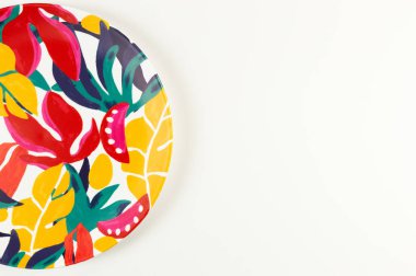 Beyaz arkaplandaki renkli plakanın üst görünümü. Egzotik bitki plakası, yaz pikniği. Düz yat, boşluğu kopyala.