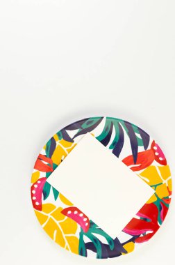 Renkli plakanın üst görüntüsü, beyaz arka planda beyaz kart. Egzotik bitki plakası, yaz pikniği. Düz yat, boşluğu kopyala.