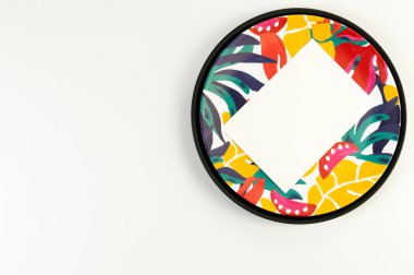 Siyah tepsinin üst görüntüsü, renkli plaka, beyaz arka planda beyaz kart. Egzotik bitki plakası, yaz pikniği. Düz yat, boşluğu kopyala.