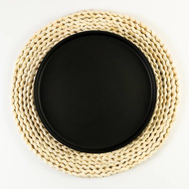 Kahverengi hasır masa paspası, beyaz arka planda siyah plaka. Saman yuvarlak tepsi, düz konum, kopyalama alanı. 