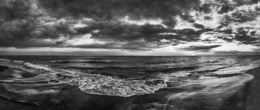 Dramatic beauty of nature with panorama of rough sea in black and white and overcast sky.