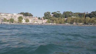 Bracciano Gölü kıyısındaki güzel ve antik Anguillara Sabazia köyünün silueti yemyeşil, beyaz ve mavi göl suyuyla bembeyaz.