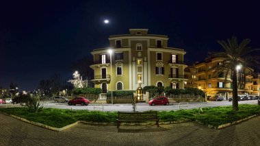 Piazza Anco Marzio 'nun gece panorama' sı Ostia Lido 'da yaya bölgesinde ve gece hayatının merkezinde Roma' nın kıyı kesiminde yer almaktadır..
