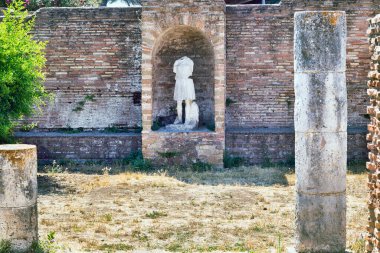 Domus della Fortuna Annonaria 'nın avlusunda Roma sütunlarının kalıntıları ve tanrıça Diana heykeli Ostia Antica' nın arkeolojik bölgesinde - Roma.