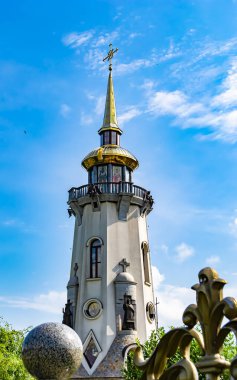 Hristiyan kilisesi, yüksek çan kulesinde ibadet için kesişiyor. Çan kulesinde haçı olan güzel bir kiliseden samimi bir duaya kadar fotoğraf çekiliyor. Çan kulesi üzerinde kilise duası açık gökyüzü üzerinde.