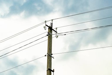 Renkli arka planda kablo olan elektrik direği yakın planda, elektrik direği ile gökyüzünün altında halat kablosu, konut binaları için elektrik direği hattı kablosu.