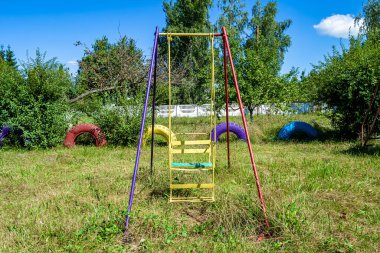 Temalı boş bir oyun parkında çekilen fotoğraf, arka plandaki çocuklar için metal salıncak, doğal olarak, çelik salıncaklı oyun alanından alınan fotoğraf, kırsal kesimdeki eski çocuk parkında insanlar olmadan salıncak.