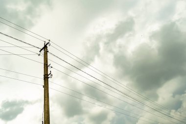 Renkli arka planda kablo olan elektrik direği yakın planda, elektrik direği ile gökyüzünün altında halat kablosu, konut binaları için elektrik direği hattı kablosu.