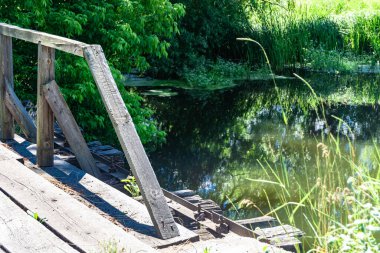 Renkli arka planda nehrin üzerinde güzel bir şekilde duran ahşap köprü. Nehrin yukarısındaki eski ahşap köprü. Doğal park için nehirde eski ahşap köprü.