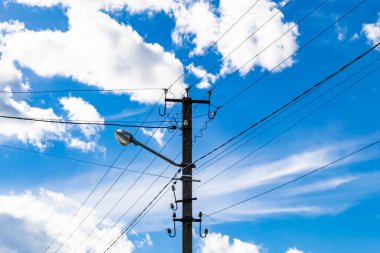 Renkli arka planda kablo olan elektrik direği yakın planda, elektrik direği ile gökyüzünün altında halat kablosu, konut binaları için elektrik direği hattı kablosu.