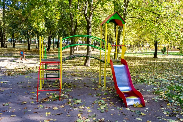 Photography on theme empty playground with metal slide for kids on background natural nature, photo consisting from playground with steel slide, slide on old playground in urban area without people
