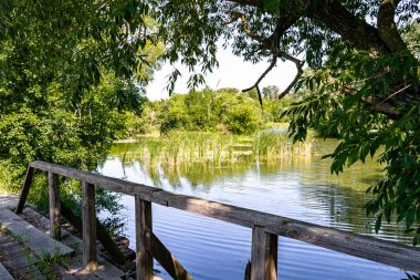 Renkli arka planda nehrin üzerinde güzel bir şekilde duran ahşap köprü. Nehrin yukarısındaki eski ahşap köprü. Doğal park için nehirde eski ahşap köprü.