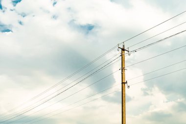 Renkli arka planda kablo olan elektrik direği yakın planda, elektrik direği ile gökyüzünün altında halat kablosu, konut binaları için elektrik direği hattı kablosu.