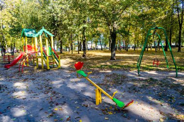 Temalı boş oyun alanı ekipmanları, arka plandaki çocuklar için doğal ortam, farklı metal oyun alanı ekipmanlarından oluşan fotoğraf, kentsel alandaki çelik çocuk parkı ekipmanları.