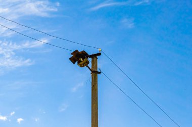 Renkli arka planda kablo olan elektrik direği yakın planda, elektrik direği ile gökyüzünün altında halat kablosu, konut binaları için elektrik direği hattı kablosu.