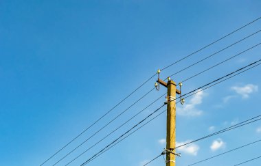 Renkli arka planda kablo olan elektrik direği yakın planda, elektrik direği ile gökyüzünün altında halat kablosu, konut binaları için elektrik direği hattı kablosu.