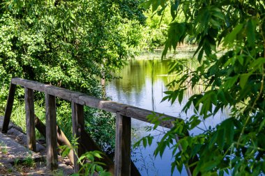 Renkli arka planda nehrin üzerinde güzel bir şekilde duran ahşap köprü. Nehrin yukarısındaki eski ahşap köprü. Doğal park için nehirde eski ahşap köprü.