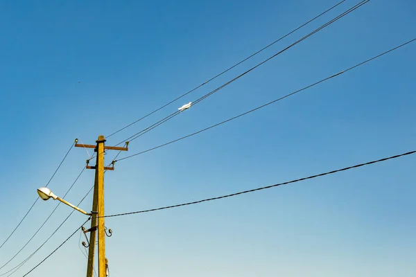 カラーを背景に線線線のついた電柱をクローズアップし 空の下に線の線のワイヤーを持つ電柱で構成される写真 住宅用電柱の線のワイヤー — ストック写真