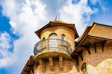 Temalı eski tuğladan bir şato. Arka planda büyük bir kulesi var. Büyük kulesi olan antik tuğladan bir şatonun fotoğrafı.