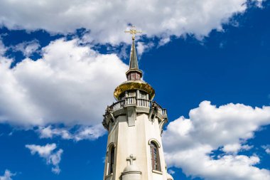 Hristiyan kilisesi, yüksek çan kulesinde ibadet için kesişiyor. Çan kulesinde haçı olan güzel bir kiliseden samimi bir duaya kadar fotoğraf çekiliyor. Çan kulesi üzerinde kilise duası açık gökyüzü üzerinde.